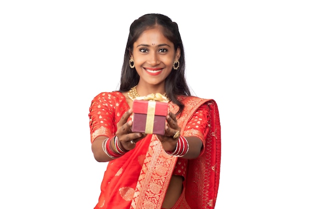 Portrait of young happy smiling Girl holding gift box on a white background