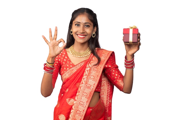 Portrait of young happy smiling Girl holding gift box on a white background