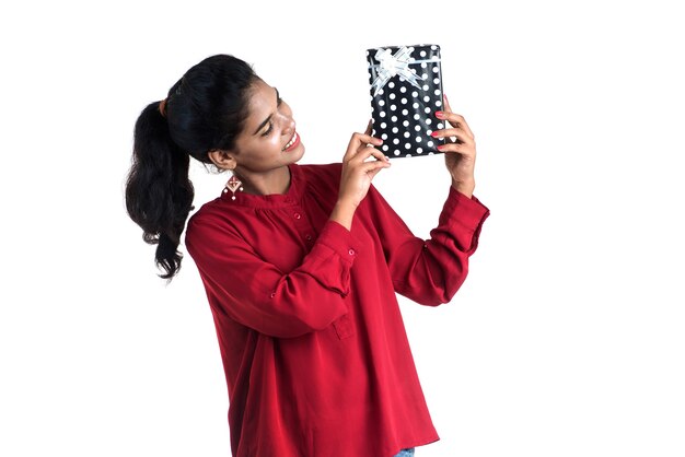 Portrait of young happy smiling Girl holding and posing with gift boxes on a white background.