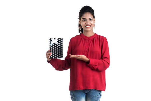 Portrait of young happy smiling Girl holding and posing with gift boxes on a white background.