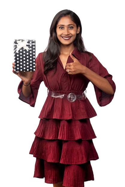 Portrait of young happy smiling Girl in red dress holding and posing with gift box on white background