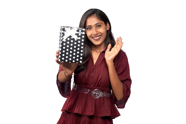 Portrait of young happy smiling Girl in red dress holding and posing with gift box on white background