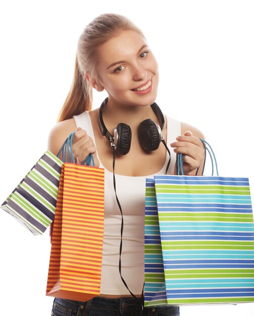 Portrait of young happy smiling woman with shopping bags, isolated over white background