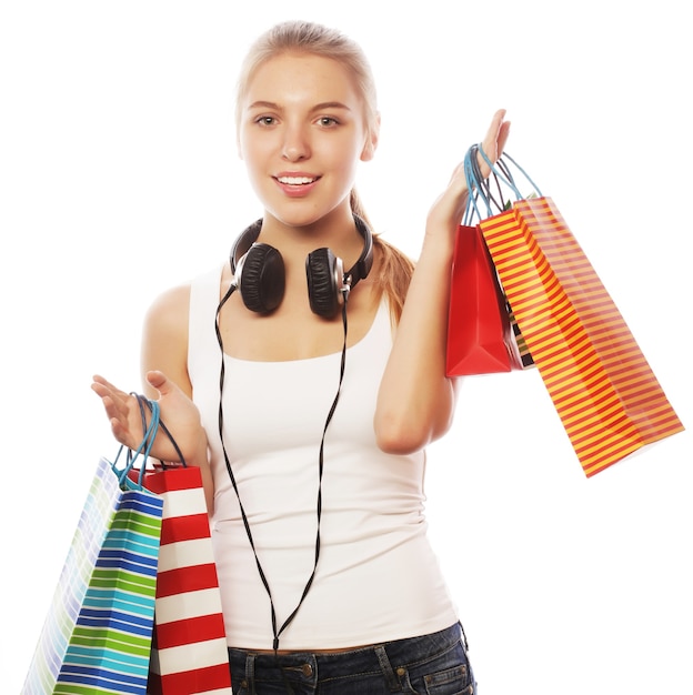 Portrait of young happy smiling woman with shopping bags, isolated over white background