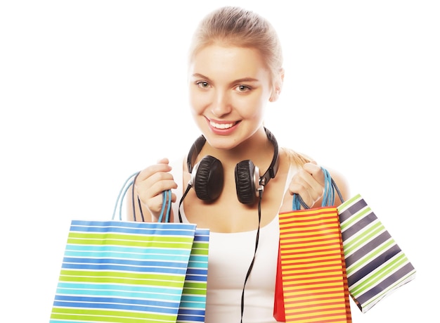 Portrait of young happy smiling woman with shopping bags, isolated over white background