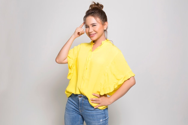 Photo portrait of young happy woman looking and thinking over grey