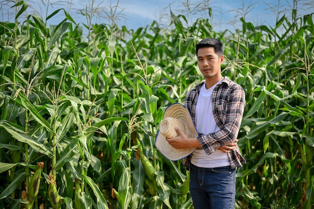 Portrait of young hardworking male farmer working in his corn field