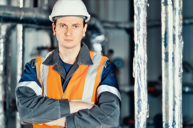 Portrait of young heavy industry engineer in protective vest and work clothes and helmet Confident worker