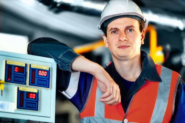 Portrait of young heavy industry engineer in protective vest and work clothes and helmet Confident worker