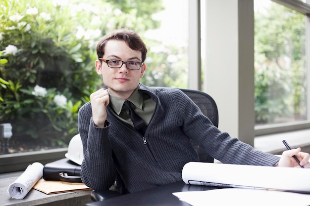 A portrait of a young hip businessman sitting in his office