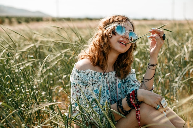 Photo portrait of a young hippie girl on a wheat field