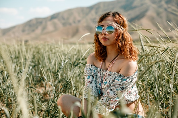 Portrait of a young hippie girl on a wheat field