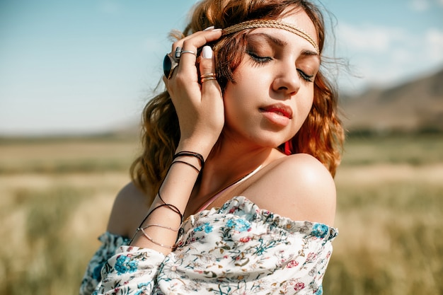 Photo portrait of a young hippie girl on a wheat field