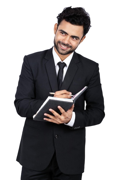 Portrait of a young Indian businessman smiling while holding a diary and pen