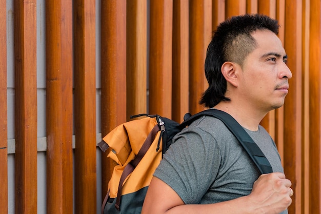 Portrait of a young indigenous man walking with a backpack