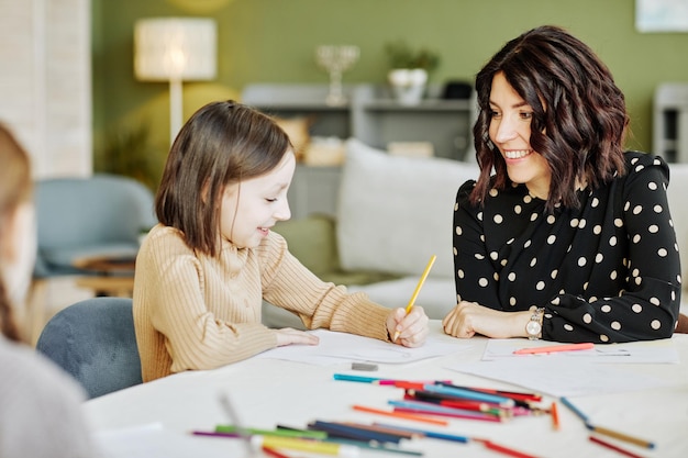 Portrait of young jewish woman drawing pictures with little daughter at home