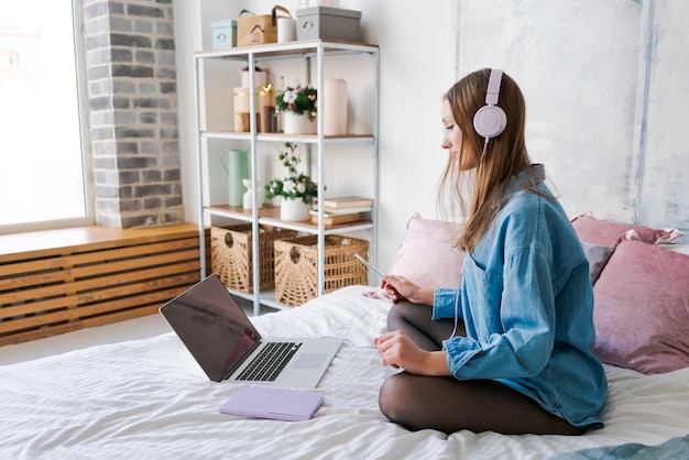 Photo portrait young joyful woman in home clothes at laptop studying online or