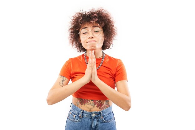 Portrait of young Kazakh woman folded her hands in prayer gesture isolated on white background Peaceful grateful trusting makes a wish concept