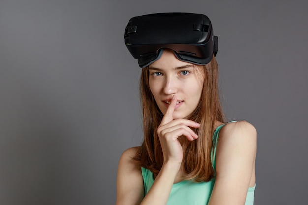 Portrait of young lady wearing VR glasses and looking at the camera