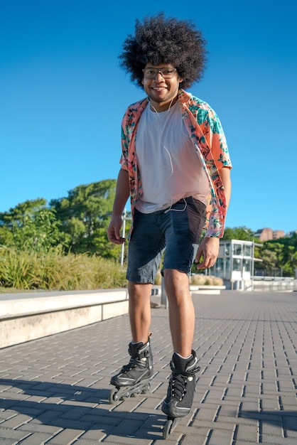 Portrait of young latin man rollerskating outdoors on the street. Sports concept. Urban concept.