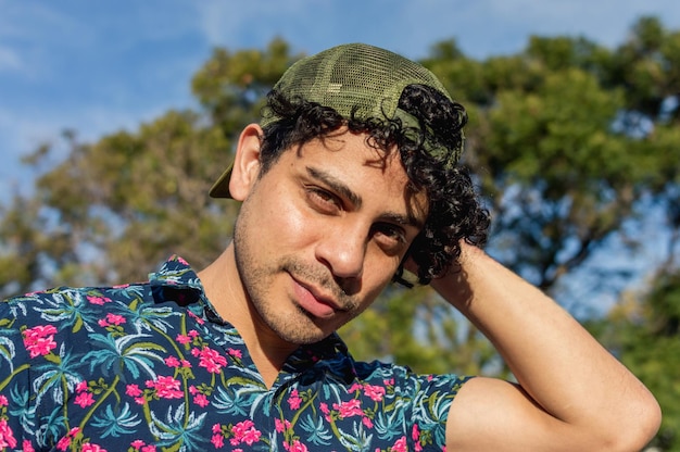 Portrait young latin man with curlers looking at the camera posing with one hand behind his head