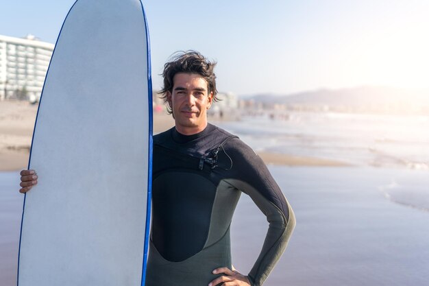 Portrait of young latin surfer on the shore of the beach with the surfboard in La Serena