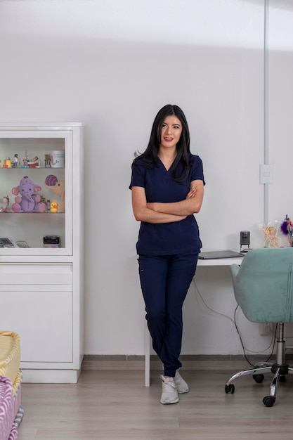 Portrait of a young Latina pediatrician standing at her office desk