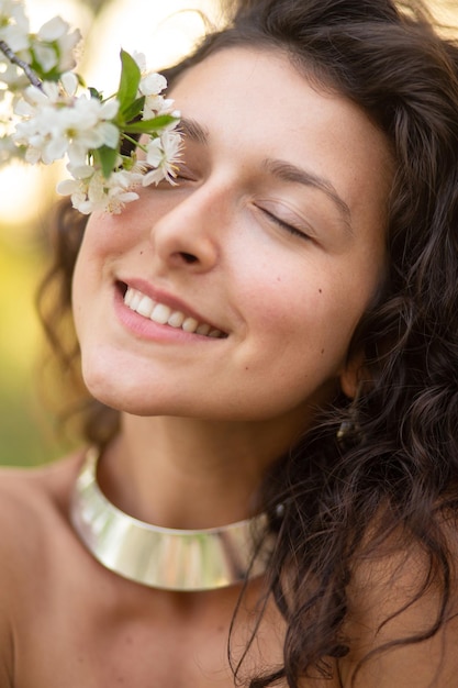 Portrait of a young laughing sexy brunette girl with a necklace around her neck