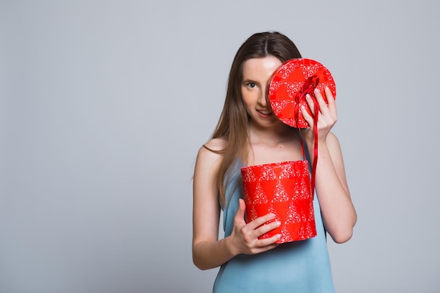 Portrait of young lovely nice sweet glamorous girl lady wearing gray top carrying gift box