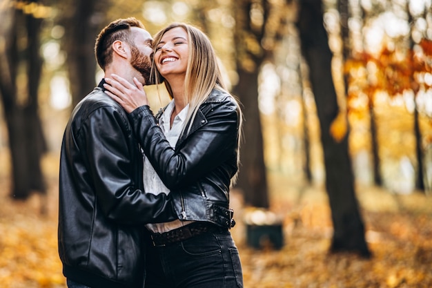 Portrait of a young loving couple. Man and woman hugging and smiling in the background of autumn park