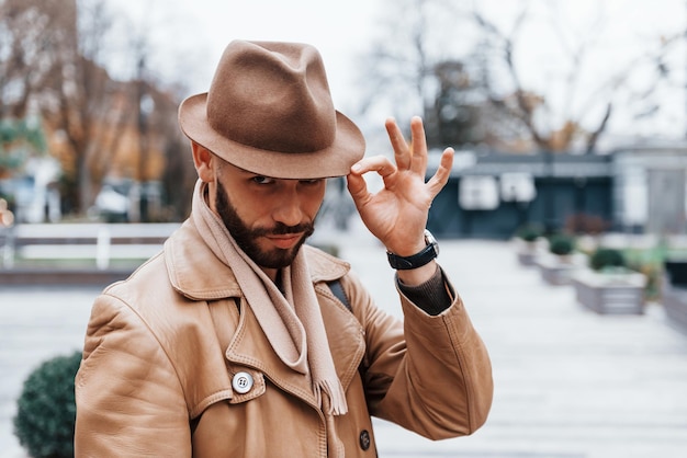 Portrait of young male model in fashionable clothes that is outdoors in the city at daytime