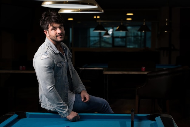 Portrait Of A Young Male Model Playing Billiards