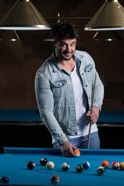 Portrait Of A Young Male Model Playing Billiards