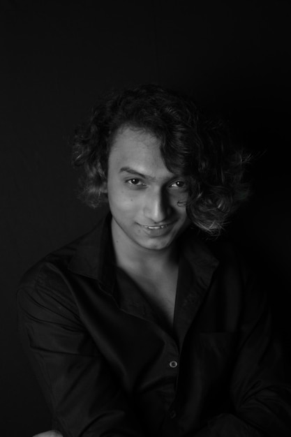 Photo portrait of young man against black background