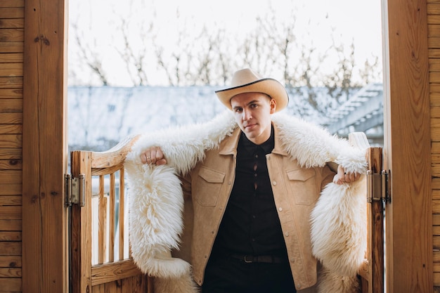 Portrait of a young man dressed in fur at a ranch in winter