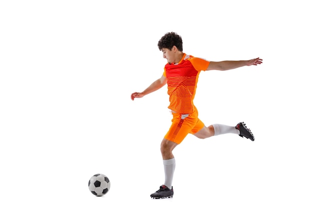 Portrait of young man football playing in motion training isolated over white studio background