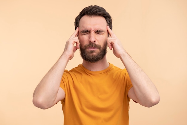 Portrait of young man having a headache and touching his temples