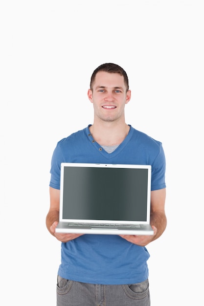 Portrait of a young man holding a laptop