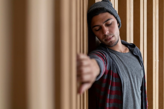 Portrait of young man Latin American hipster with relaxed attitude Wooden background