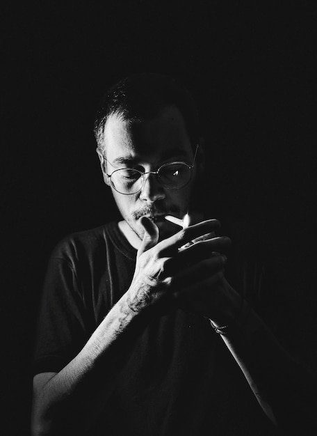 Photo portrait of young man making face against black background