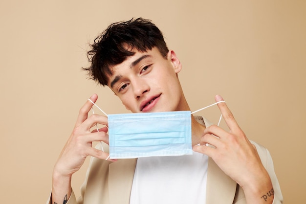 Portrait of a young man a man in a light jacket medical mask Lifestyle unaltered