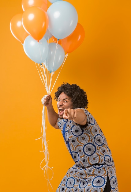 Portrait young man at party with balloons