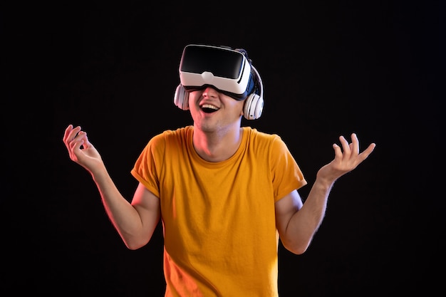 Portrait of young man playing vr in headphones on dark desk gaming visual vision d tech