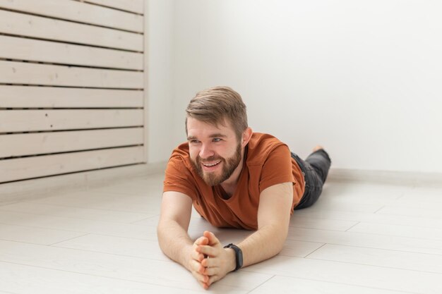 Photo portrait of young man sitting on floor at home