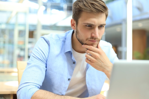 Portrait of young man sitting at his desk in the office.