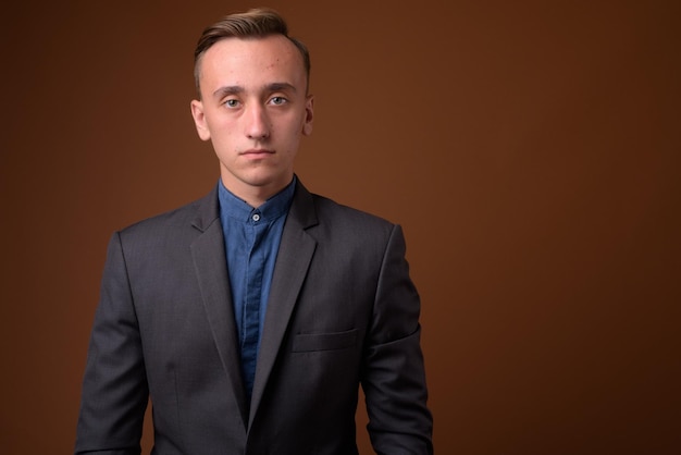 Photo portrait of young man standing against black background