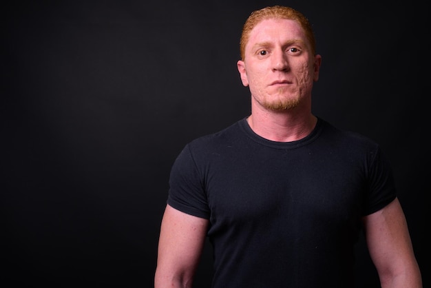 Photo portrait of young man standing against black background