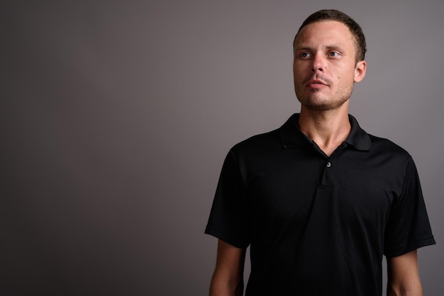 Photo portrait of young man standing against black background