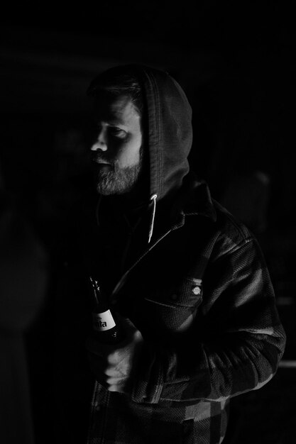 Photo portrait of young man standing against black background