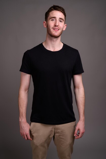 Photo portrait of young man standing against gray background